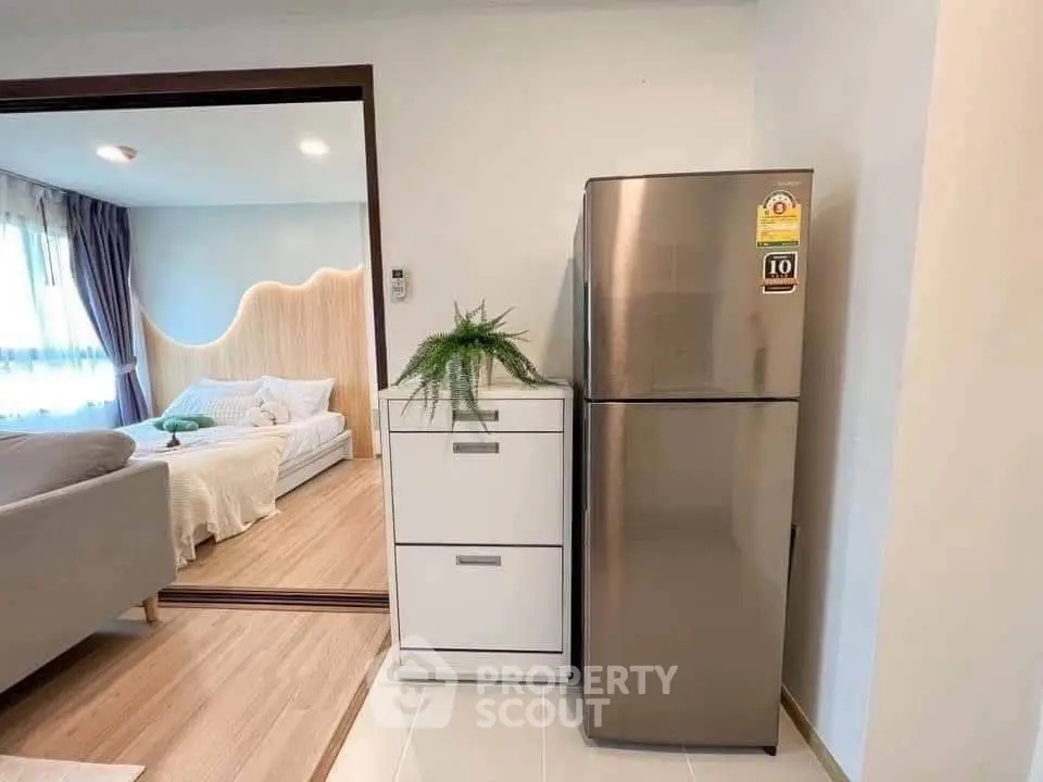 Modern apartment interior with sleek fridge and cozy living area
