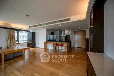 Spacious open-plan living room with modern kitchen and wooden flooring