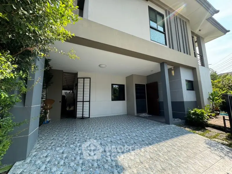 Modern two-story house with spacious covered parking and stylish exterior design.