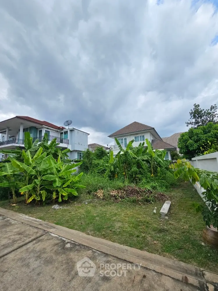 Charming suburban homes with lush gardens under a cloudy sky