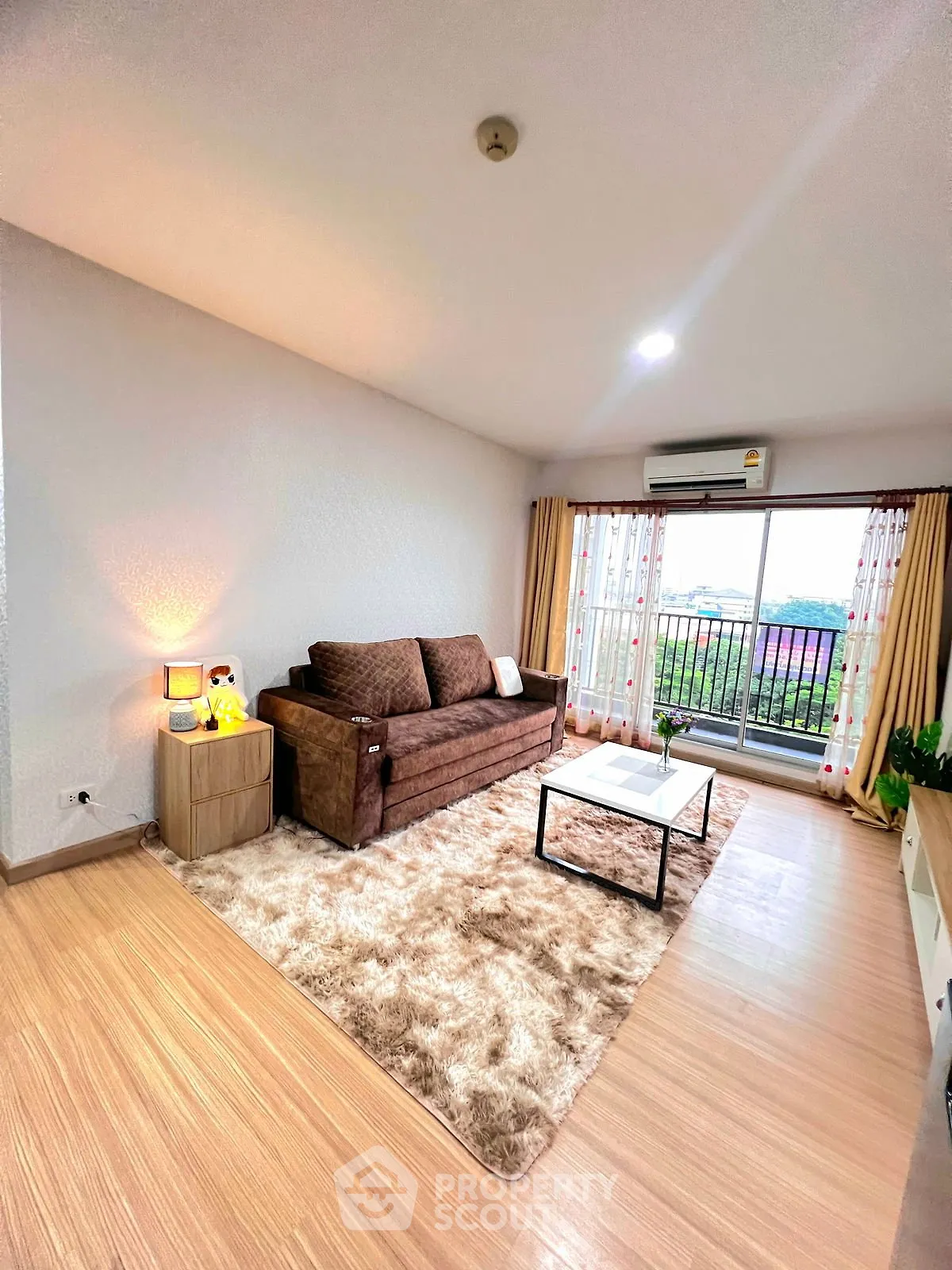 Spacious living room with cozy sofa and balcony view in modern apartment