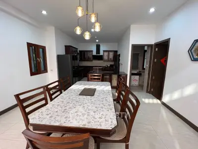 Spacious dining area with elegant wooden table and modern kitchen in open layout