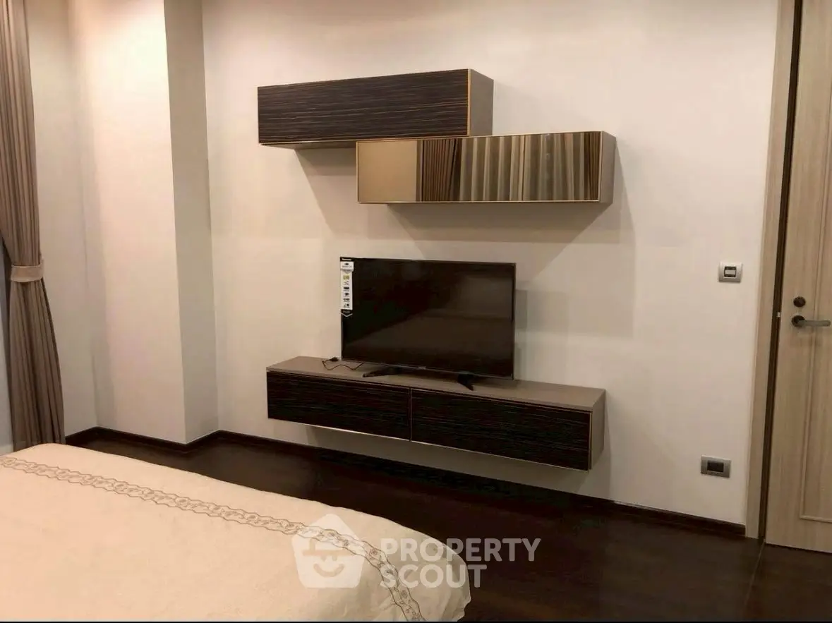 Modern bedroom with sleek TV setup and stylish wall-mounted cabinets.