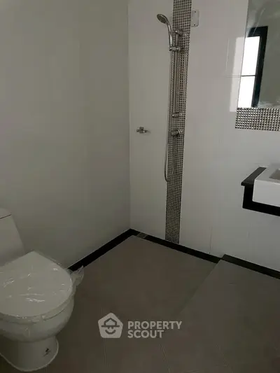 Modern bathroom with sleek shower and toilet in minimalist design