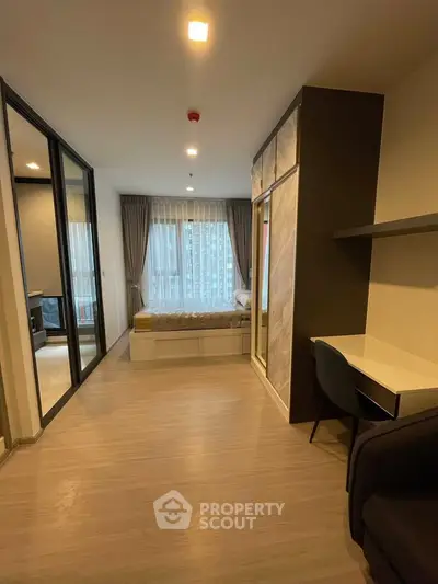 Modern studio apartment with sleek design and large windows offering city views.