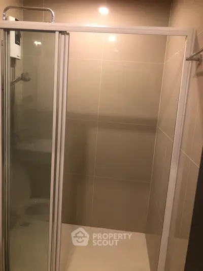 Modern bathroom with sleek shower enclosure and neutral tiles