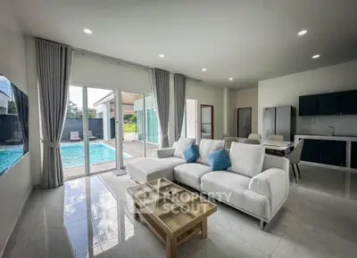 Luxurious living room with pool view, modern furniture, and open layout in a contemporary home.