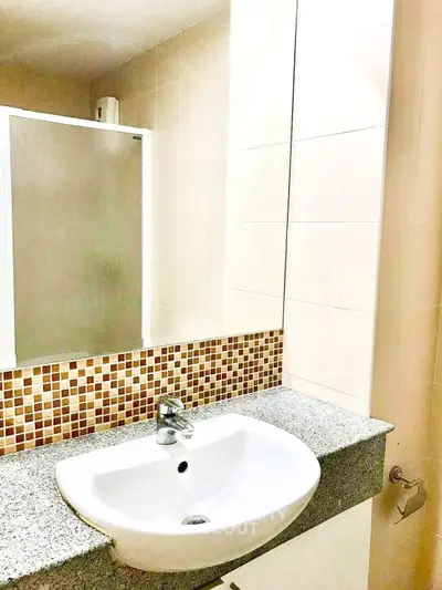 Modern bathroom with stylish sink and mosaic tile accents