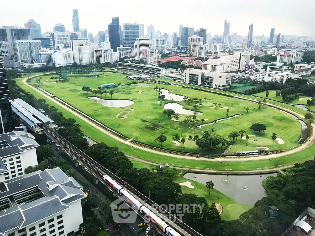 Stunning aerial view of urban golf course surrounded by skyscrapers, offering a unique blend of nature and city life.