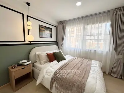 Cozy bedroom with modern decor and large window offering natural light