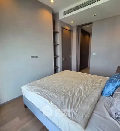 Modern bedroom with sleek design and built-in shelving, perfect for urban living.