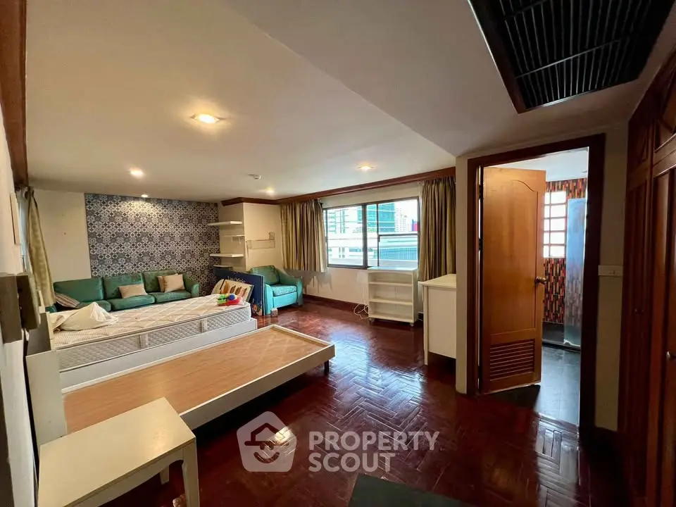 Spacious living room with parquet flooring and modern decor in a stylish apartment.