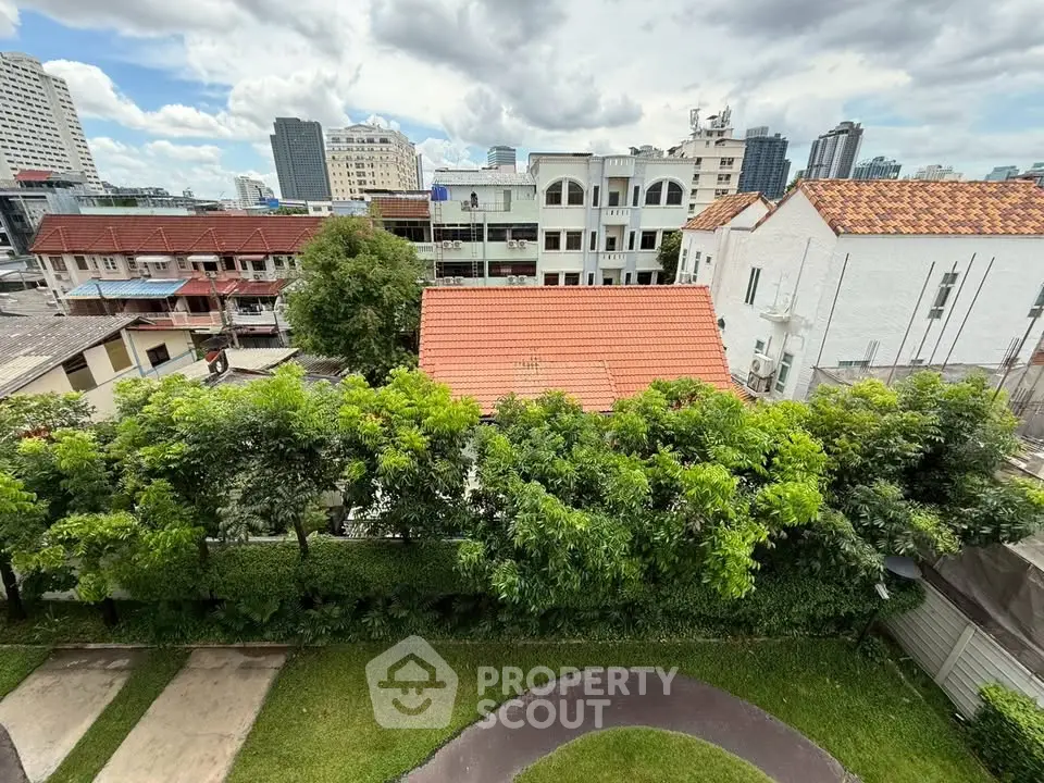 Scenic urban view with lush greenery and diverse architecture under a vibrant sky.