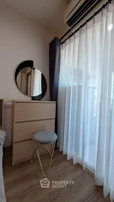 Cozy bedroom corner with modern dresser and stool by window