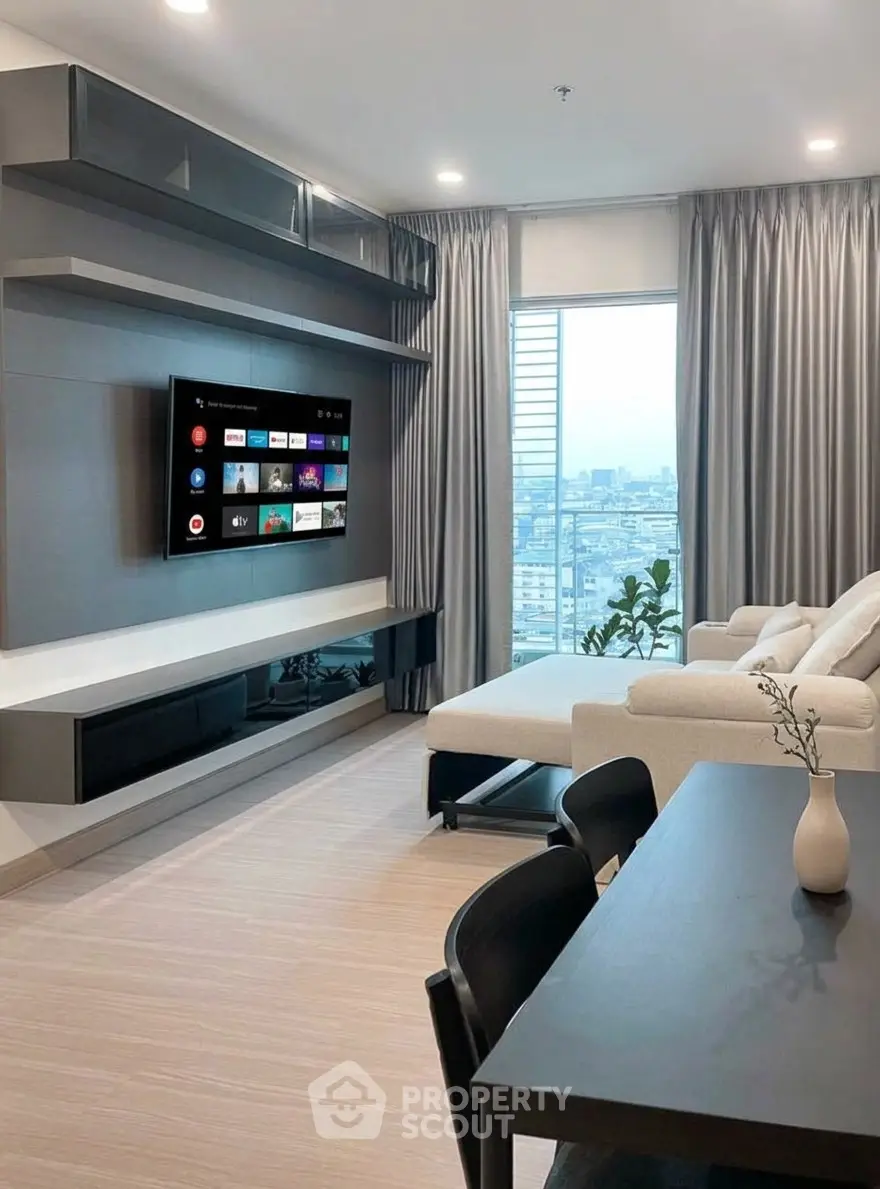 Modern living room with sleek furniture and city view, featuring a wall-mounted TV and elegant decor.