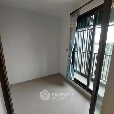 Bright empty room with balcony access and city view, ideal for customization.