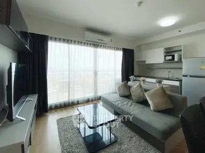 Modern living room with sleek furniture and large window offering city view