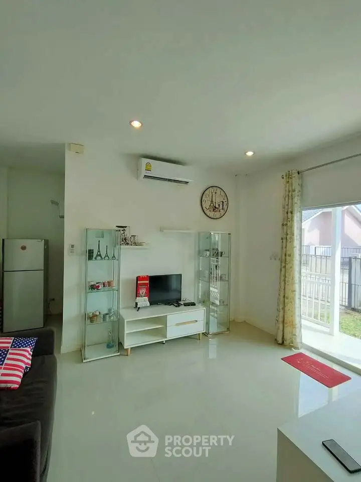 Bright living room with modern decor and large window overlooking garden