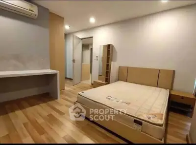 Spacious bedroom with modern furnishings and wooden flooring, ideal for comfort and relaxation.