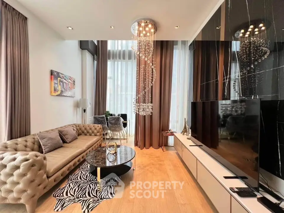 Luxurious living room with high ceilings, elegant chandelier, and modern decor in a stylish apartment.