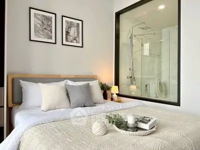 Modern bedroom with ensuite bathroom featuring glass shower and elegant decor.