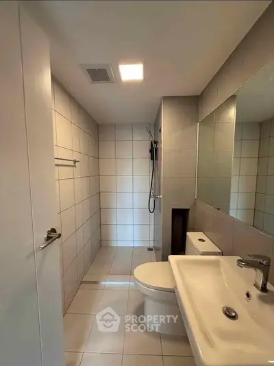 Modern bathroom with sleek fixtures and spacious shower area in a contemporary home.