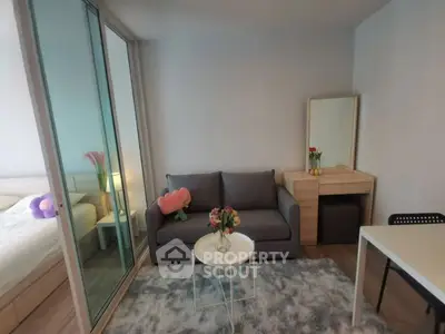 Modern living room with cozy sofa, stylish decor, and sliding glass doors leading to a bedroom.