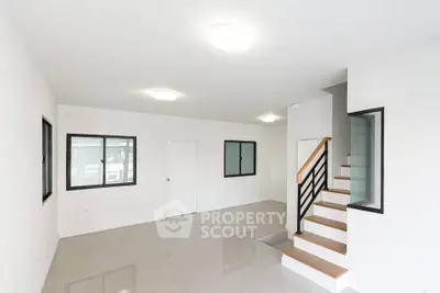 Spacious modern living room with sleek staircase and large windows