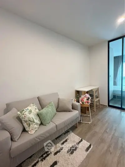 Cozy living room with modern decor and sliding glass door to bedroom