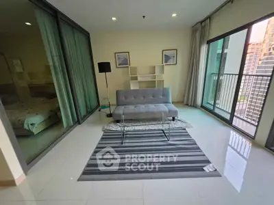 Modern living room with sleek furniture and large windows offering city views.