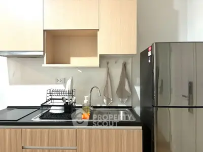 Modern kitchen with sleek cabinets and stainless steel fridge, ideal for urban living.