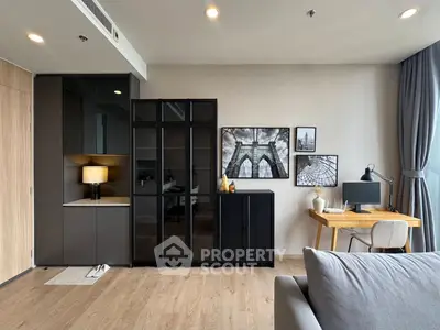 Modern living room with stylish decor and workspace, featuring elegant furniture and natural light.