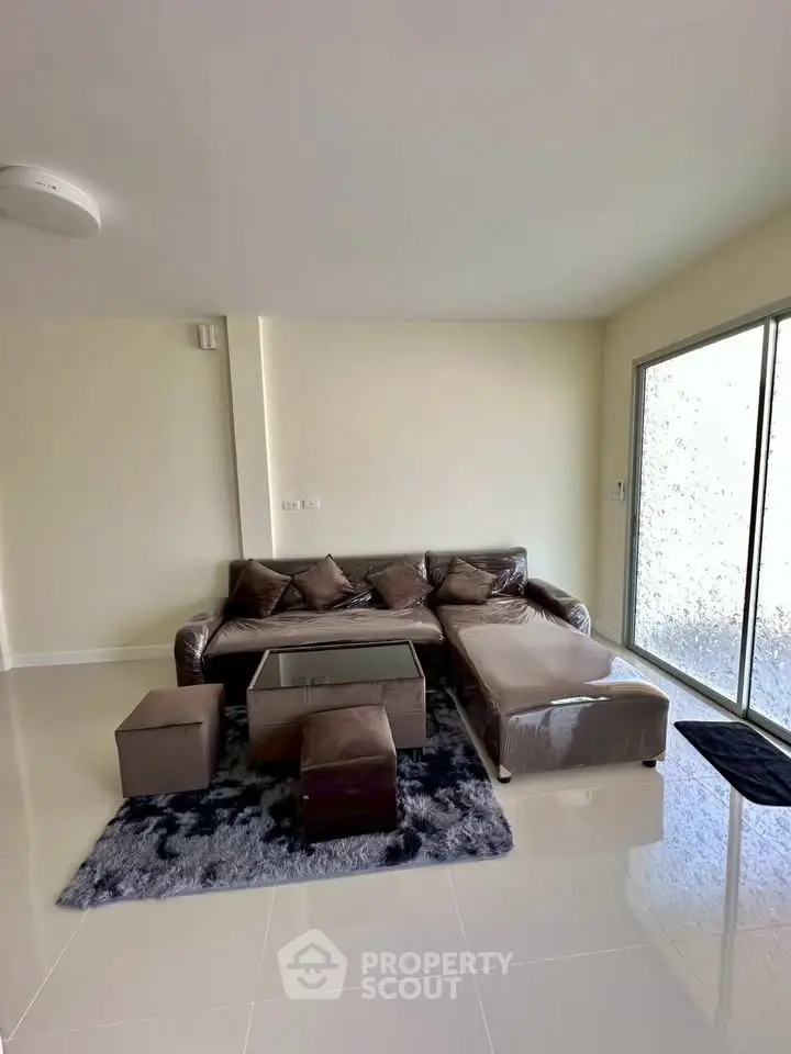 Modern living room with sleek furniture and large window for natural light.
