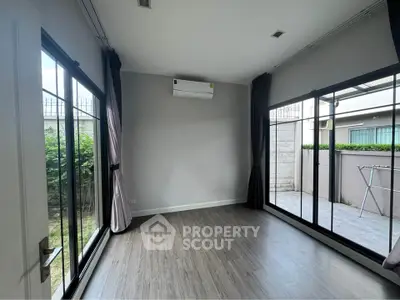 Spacious room with large windows and garden view, perfect for a bright and airy living space.
