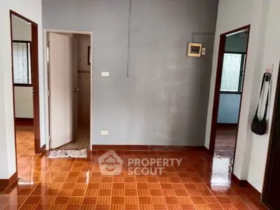 Spacious interior with tiled flooring and multiple doorways, ideal for customization.