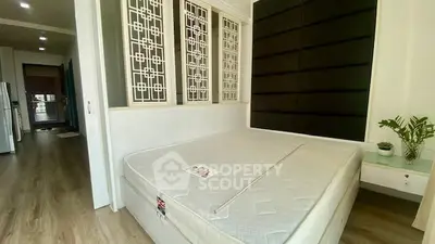 Modern bedroom with stylish decor and natural light, featuring a comfortable mattress and elegant design.