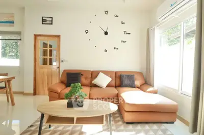 Modern living room with stylish wall clock and cozy leather sofa