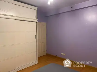 Spacious bedroom with built-in wardrobe and wooden flooring