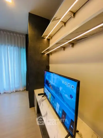 Modern living room with sleek TV setup and stylish shelving, featuring floor-to-ceiling windows and elegant curtains.