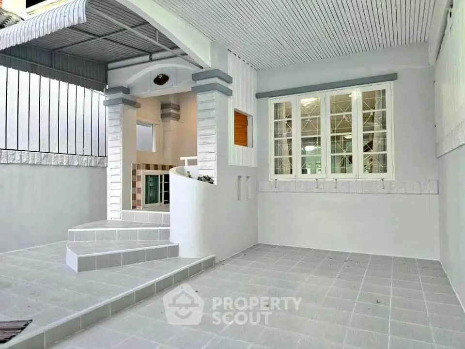 Charming white exterior with covered entrance and tiled steps, perfect for welcoming guests.