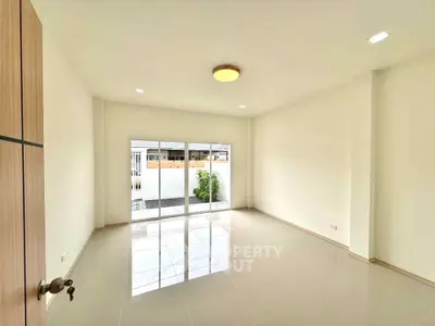Spacious and bright living room with large windows and modern lighting