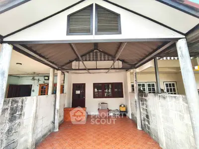 Charming covered patio with tiled flooring and rustic wooden accents, perfect for outdoor relaxation and gatherings.