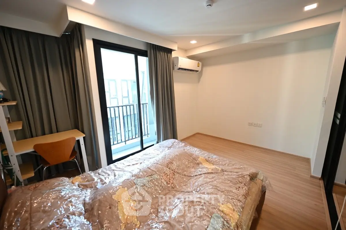 Spacious bedroom with balcony access in modern apartment