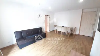Spacious living room with wooden flooring and modern furniture in a bright apartment.