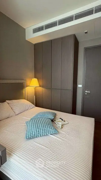 Cozy bedroom with modern design, featuring a comfortable bed and stylish lighting.