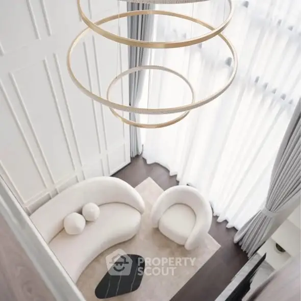 Luxurious modern living room with elegant chandelier and stylish furniture, featuring floor-to-ceiling windows.