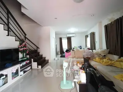 Spacious living room with modern staircase and cozy seating area, perfect for family gatherings.