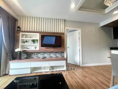 Modern living room with stylish decor and wall-mounted TV, featuring wooden flooring and elegant furnishings.
