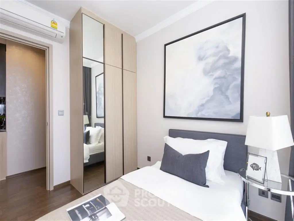 Modern bedroom with stylish decor and mirrored wardrobe