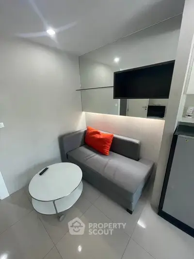 Modern compact living room with sleek sofa and wall-mounted TV